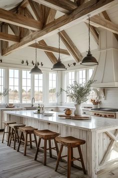 a large kitchen with wooden beams and white counter tops, an island in the middle is surrounded by stools