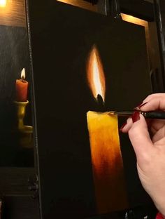 a woman is painting a candle on a canvas