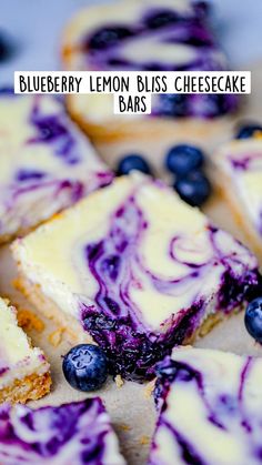 blueberry cheesecake bars are cut into squares and arranged on a cutting board with fresh blueberries