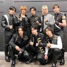 a group of young men standing next to each other in front of a garage door