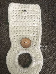 a crocheted cell phone case with a wooden button on the front and side