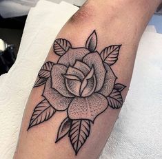 a black and white rose tattoo on the arm