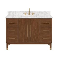 a bathroom vanity with marble top and two gold faucets on the sink area