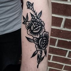 a black and white flower tattoo on the arm