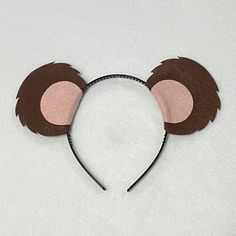 a brown and pink mouse ears on top of a headband with hair clips attached to it