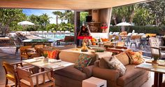 a living room filled with furniture and lots of windows overlooking the pool side patio area