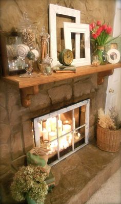 a fireplace with candles and pictures on it