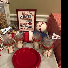 a table topped with red and white baseball themed desserts next to a sign that says balls & bats