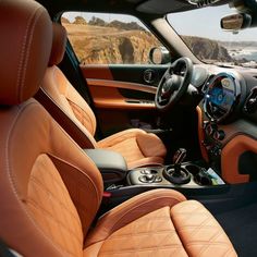 the interior of a vehicle with tan leather and black trims, along with an ocean view