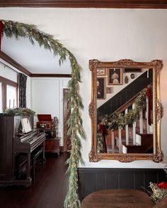 a christmas garland is hanging on the wall next to a piano