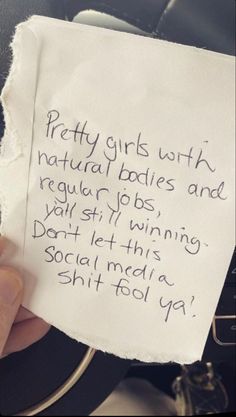 a person holding up a piece of paper with writing on it that says pretty girls with natural bodies and regular jobs