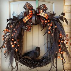 a wreath that is hanging on the front door with a bird sitting in it's nest