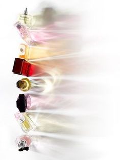 an abstract photograph of bottles of perfumes in different colors and sizes on a white background