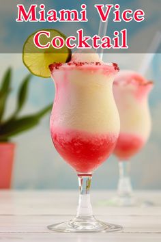 two glasses filled with pink and white cocktails on top of a table next to a plant