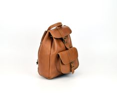 "This full grain leather backpack is more than practical and stylish... our sumptuous leather satchel is classic! Simple and strong lighter-weight design, perfect bag to carry your basic stuff, tablet, mobile phone, wallet, books, etc. Buckle closure on main flap with drawstring closure underneath. 1 main large roomy main compartment and 1 front pocket with buckle closures. * COLORS (see the last photo): ➀ Natural ➁ Black ➂ Tobacco ➃ Dark Brown ➄ Waxed Light Brown ➅ Waxed Dark Brown ➜ Note for N Brown Note, Handmade Leather Backpack, Backpack Gift, Everyday Backpack, Women's Backpack, Backpack For Women, Leather Rucksack, Easy A, Women Leather Backpack