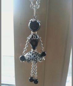 a black and white beaded necklace hanging from a hook on a door handle,