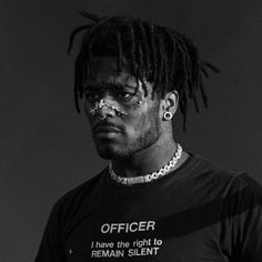 a black and white photo of a man with dreadlocks wearing a shirt that says officer i have the right to remain silent