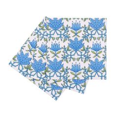 two napkins with blue and green designs on white paper, one is folded to the side