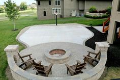 an outdoor fire pit with chairs around it