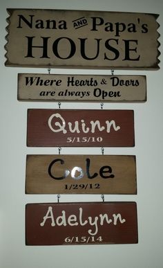 three wooden signs hanging from the side of a white wall with names on them,