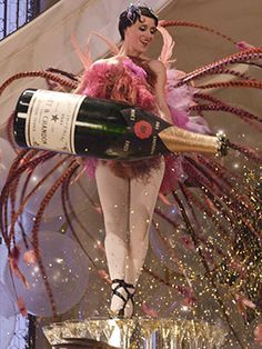 a woman dressed as a fairy holding a bottle of wine