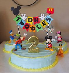 a birthday cake with mickey mouse figures on it