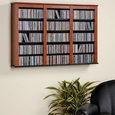 a wall mounted dvd rack with many different movies on the shelves in front of it