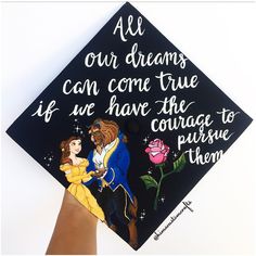 a hand holding a graduation cap with an image of beauty and the beast on it that says, all our dreams can come true if we have the courage to pursue them