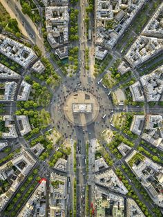 an aerial view of a city with lots of tall buildings and trees in the middle