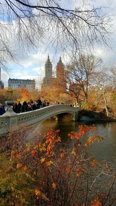 many people are walking across a bridge over a river