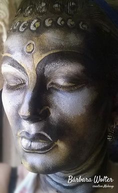 a close up of a buddha statue with its eyes closed