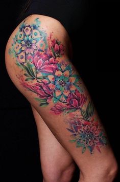 a woman's thigh with flowers painted on it and the bottom half of her leg