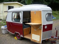 an old camper van is parked in the driveway with its doors open and it's door opened