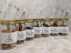 five jars filled with spices sitting on top of a counter next to a marble wall