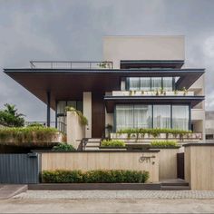 a modern house with plants growing on the balconies