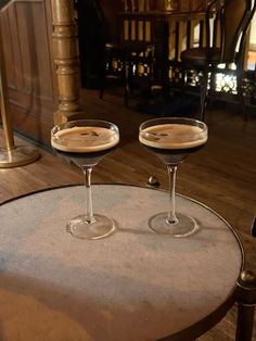 two martini glasses sitting on top of a table