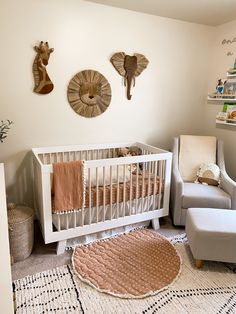 a baby's room with two giraffes on the wall and a chair