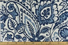 blue and white fabric with large flowers on it, in the middle of a ruler