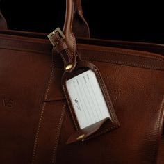 Every bag benefits from an instantly recognizable travel tag. The Signature leather luggage tag adds both style and practicality, ensuring your bag is easy to identify or returned to its rightful owner by honest hands. Featuring a brass buckle and a flap opening where your personal information is securely visible under a transparent cover, this refined leather luggage tag is handmade from the highest quality vegetable-tanned Italian leather with beautifully distinct stitching around the edges th Leather Luggage Tag, Travel Tags, Leather Luggage Tags, Solid Brown, Leather Luggage, Brass Buckle, Black Solid, Luggage Tag, Classic Leather