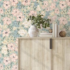 a vase filled with flowers sitting on top of a wooden cabinet next to a wall