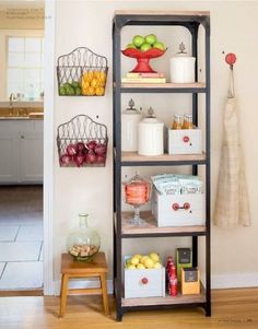 an open book shelf filled with lots of fruit and drinks on top of a hard wood floor