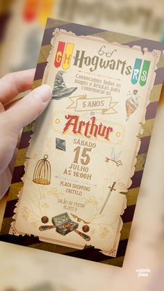 a hand holding up a harry potter birthday party card with hogwarts on it