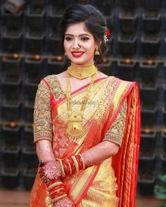 a woman in an orange and gold sari