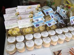 an assortment of cookies and pastries on display at a market stall with labels for sale