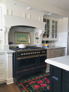 a kitchen with white cabinets and black stove