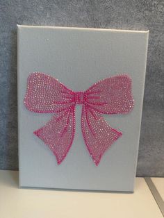 a white canvas with pink bow on it