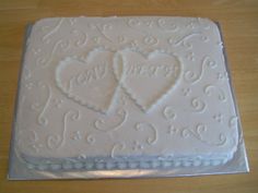 a white cake with two hearts on it