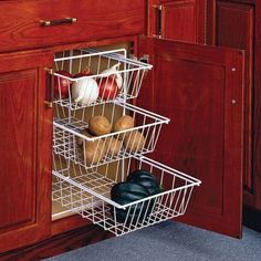 a kitchen cabinet with three baskets in it