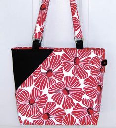 a red and white flowered purse hanging from a hook