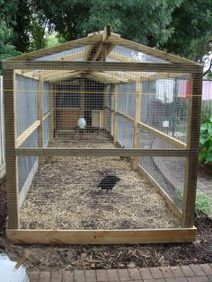 a small chicken coop in the middle of a yard with grass and dirt on the ground